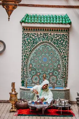 a man sitting on the floor in front of a shrine at Les Borjs De La Kasbah in Marrakech