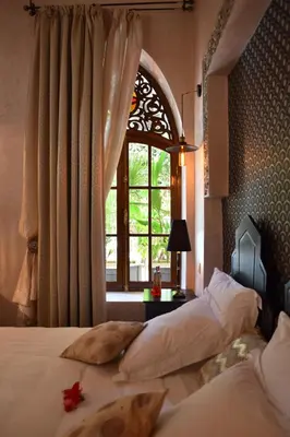 a bedroom with two beds and a window at Demeures d'Orient Riad & Spa in Marrakech