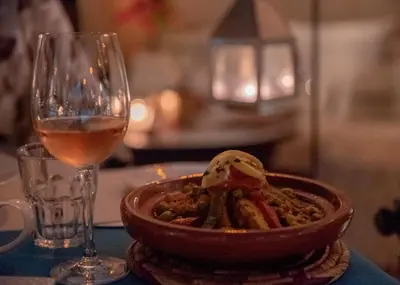 a bowl of food next to a glass of wine at Demeures d'Orient Riad & Spa in Marrakech