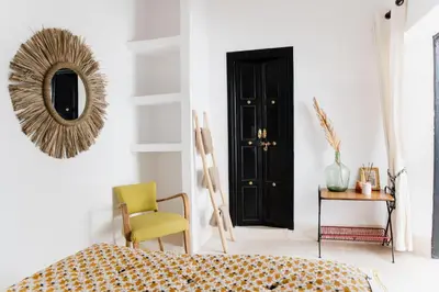 a bedroom with a black door and a yellow chair at Riad 27 & SPA entièrement privatisé in Marrakech