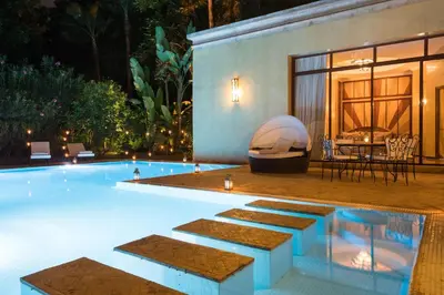 a swimming pool at night with a table and chairs at Es Saadi Marrakech Resort - Palace in Marrakech