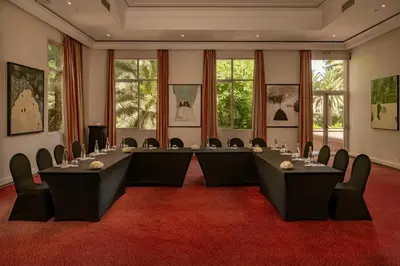 a conference room with tables and chairs on a red carpet at Es Saadi Marrakech Resort - Palace in Marrakech