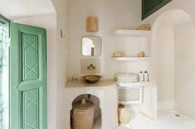 a bathroom with a sink and a green door at Riad Privé Dar Yaël in Marrakech