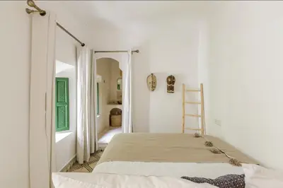 a white bedroom with a bed and a ladder at Riad Privé Dar Yaël in Marrakech