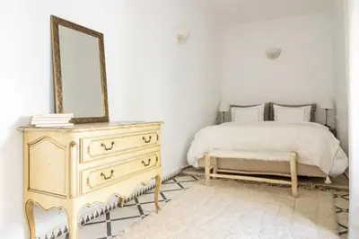 a bedroom with a bed and a dresser and a mirror at Riad Privé Dar Yaël in Marrakech