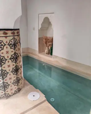 a room with green flooring and a shelf with a window at Riad Privé Dar Yaël in Marrakech