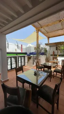 a patio with tables and chairs on a patio at RIAD LUXE LOCATION le GRIZZLY in Marrakech