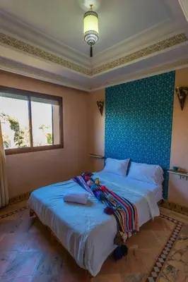 a bedroom with a large bed with a blue wall at Villa Dahlia in Marrakech