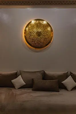 a circular light fixture on a wall with pillows at Villa Dahlia in Marrakech
