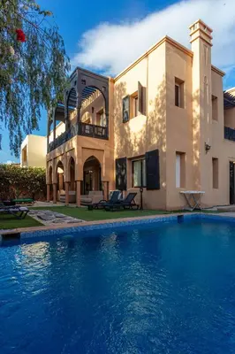 a house with a swimming pool in front of a house at Villa Dahlia in Marrakech