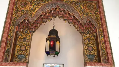 a light hanging from a wall with an ornate ceiling at DAR SAFIRA in Marrakech