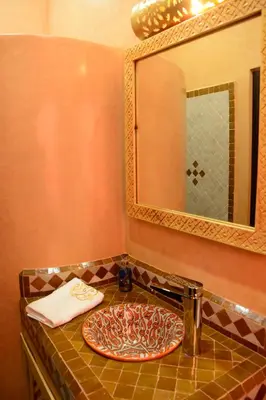 a bathroom sink with a plate on a counter with a mirror at Riad Bab Nour in Marrakech
