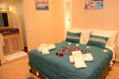 a bedroom with a bed with towels and flowers on it at Riad Bab Nour in Marrakech