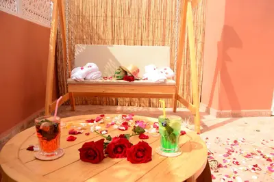 a table with roses and stuffed animals on a swing at Riad Bab Nour in Marrakech