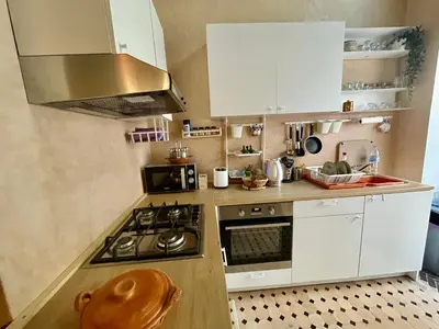 a kitchen with white cabinets and a stove top oven at Au Riad des Deux Patios - Marrakech in Marrakech