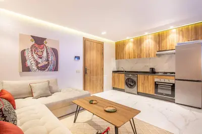 a living room with a white couch and a kitchen at Design, résidence standing, Salon modern, Terrasse in Marrakech