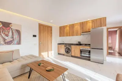 a living room with a couch and a kitchen at Design, résidence standing, Salon modern, Terrasse in Marrakech