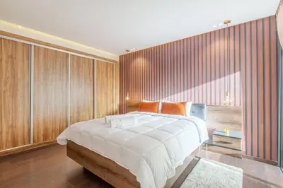 a bedroom with a large bed with wooden walls at Design, résidence standing, Salon modern, Terrasse in Marrakech