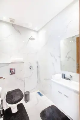 a white bathroom with a toilet and a sink at Design, résidence standing, Salon modern, Terrasse in Marrakech