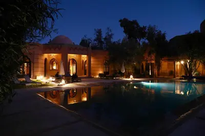 a house with a swimming pool at night at Villa Al Assala Palmeraie in Marrakech