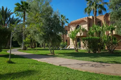 a sidewalk in front of a building with palm trees at Villa Al Assala Palmeraie in Marrakech