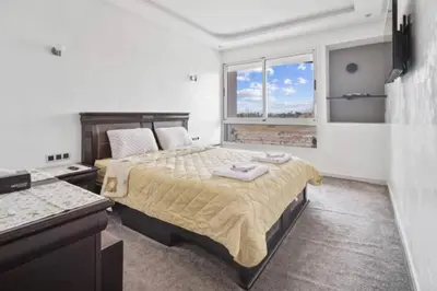 a bedroom with a large bed and a window at Magnifique appartement en plein centre ville in Marrakech
