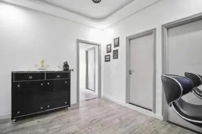 a living room with a black chair and a dresser at Magnifique appartement en plein centre ville in Marrakech