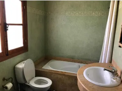 a bathroom with a toilet and a sink and a tub at Riad Mhidou Marrakech in Marrakech
