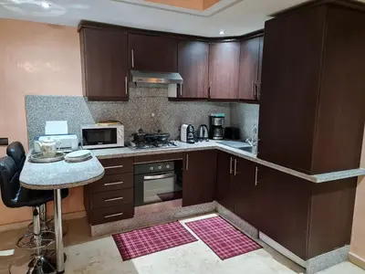 a kitchen with wooden cabinets and a counter top at 1 Bed Flat - Sleeps 2 - Parking - Wifi in Marrakech