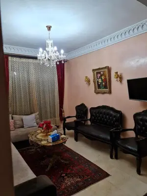a living room with black leather furniture and a chandelier at 1 Bed Flat - Sleeps 2 - Parking - Wifi in Marrakech