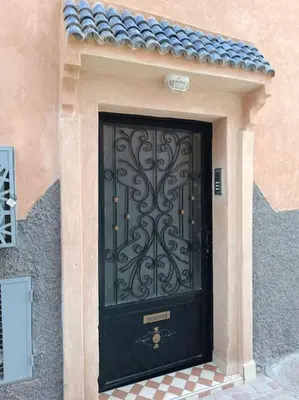 a black door on a building with a tile floor at Oasis appart sérénité in Marrakech