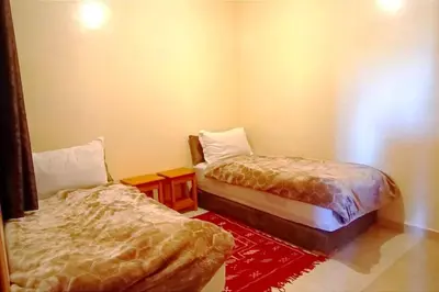 a room with two beds and a red rug at Oasis appart sérénité in Marrakech