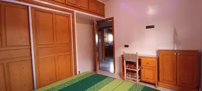 a bedroom with a bed and a desk and cabinets at Oasis appart sérénité in Marrakech