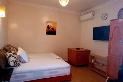 a bedroom with a bed and a dresser and a clock at Studio l'Oasis de la Palmeraie in Marrakech