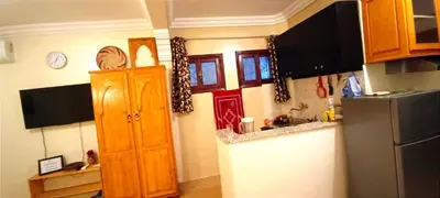 a kitchen with wooden cabinets and a refrigerator at Studio l'Oasis de la Palmeraie in Marrakech
