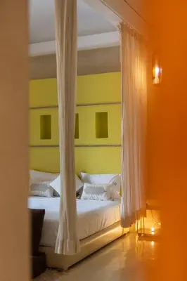 a bedroom with two white beds and yellow walls at Les Jardins de Kesali By La Siredrah in Marrakech