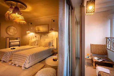 a bedroom with two beds and a table in a room at LES TANNEURS PENTHOUSE MARRAKECH in Marrakech
