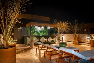 a patio with tables and lounge chairs and plants at LES TANNEURS PENTHOUSE MARRAKECH in Marrakech