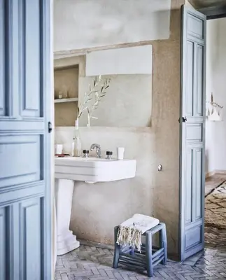 a bathroom with a sink and a mirror and a stool at Riad Kitula in Marrakech