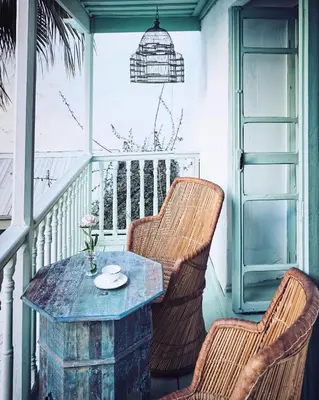 a porch with two chairs and a table on a balcony at Riad Kitula in Marrakech
