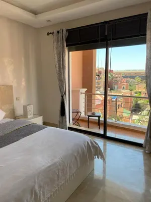 a bedroom with a bed and a large window at Résidence Las Palmeras in Marrakech