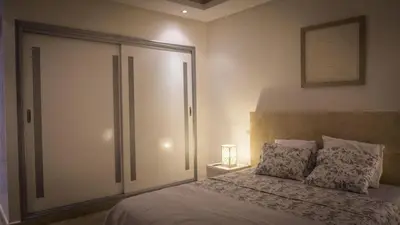 a bedroom with a bed with a sliding glass door at Résidence Las Palmeras in Marrakech