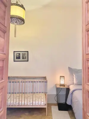 a bedroom with a crib and a lamp at Riad Rossi in Marrakech