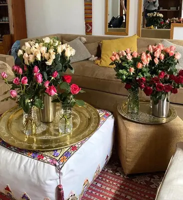 a living room with two tables with vases of flowers at Riad Rossi in Marrakech