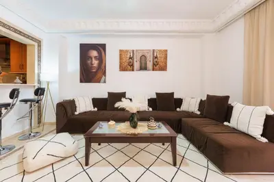 a living room with a couch and a table at Appartement Chic Gueliz Plaza avec Vue in Marrakech