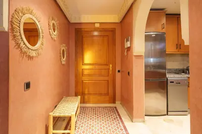 a kitchen with a wooden door and a stool at Appartement Chic Gueliz Plaza avec Vue in Marrakech