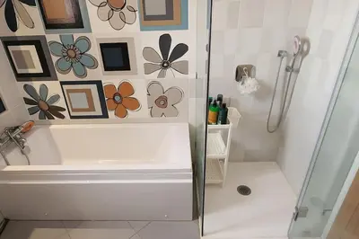 a bathroom with a shower and a tub and a sink at Villa moderne avenue M6 in Marrakech