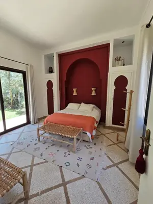 a bedroom with a bed with a red headboard at Villa Ily Marrakech Oasis privée avec piscine chauffée et panorama Atlas in Marrakech