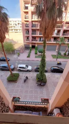 a parking lot with cars parked in front of a building at Cosy apartment in Marrakesh, Guliz in Marrakech