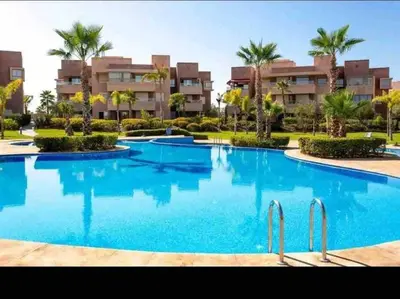a large swimming pool in front of a building at Appartement, Prestigia Marrakech in Marrakech